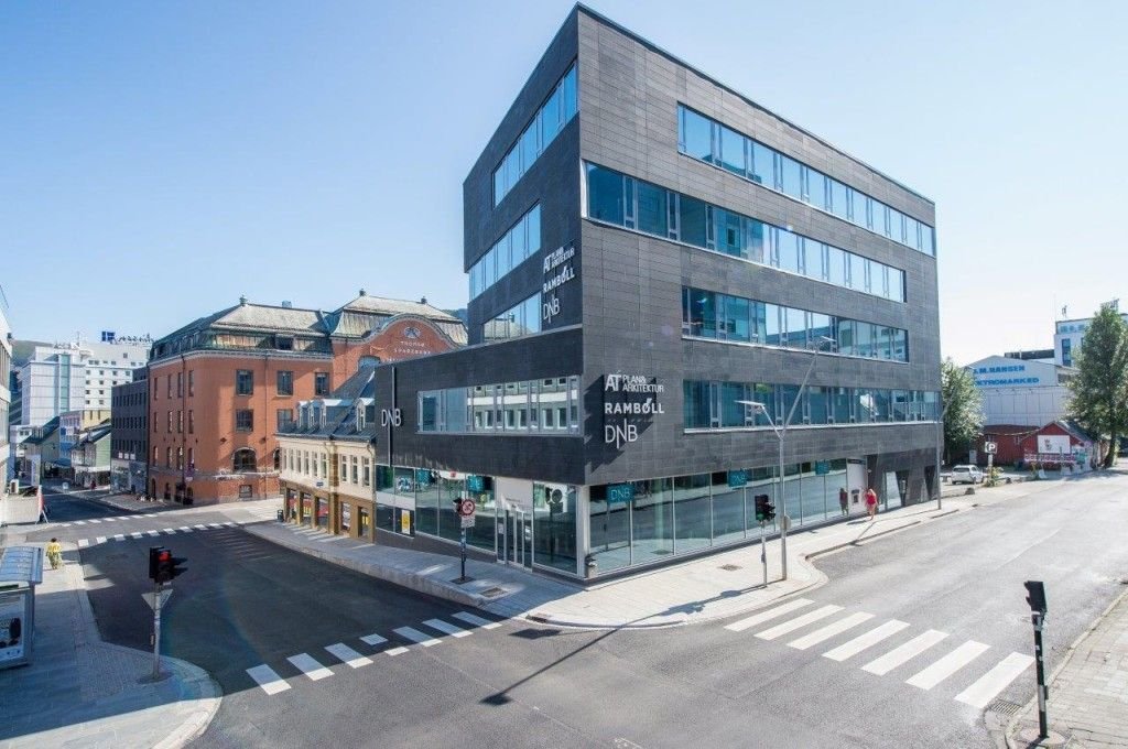 Kontorbygget i Grønnegata 65 i Tromsø, et mørkt bygg i seks etasjer på et gatehjørne.